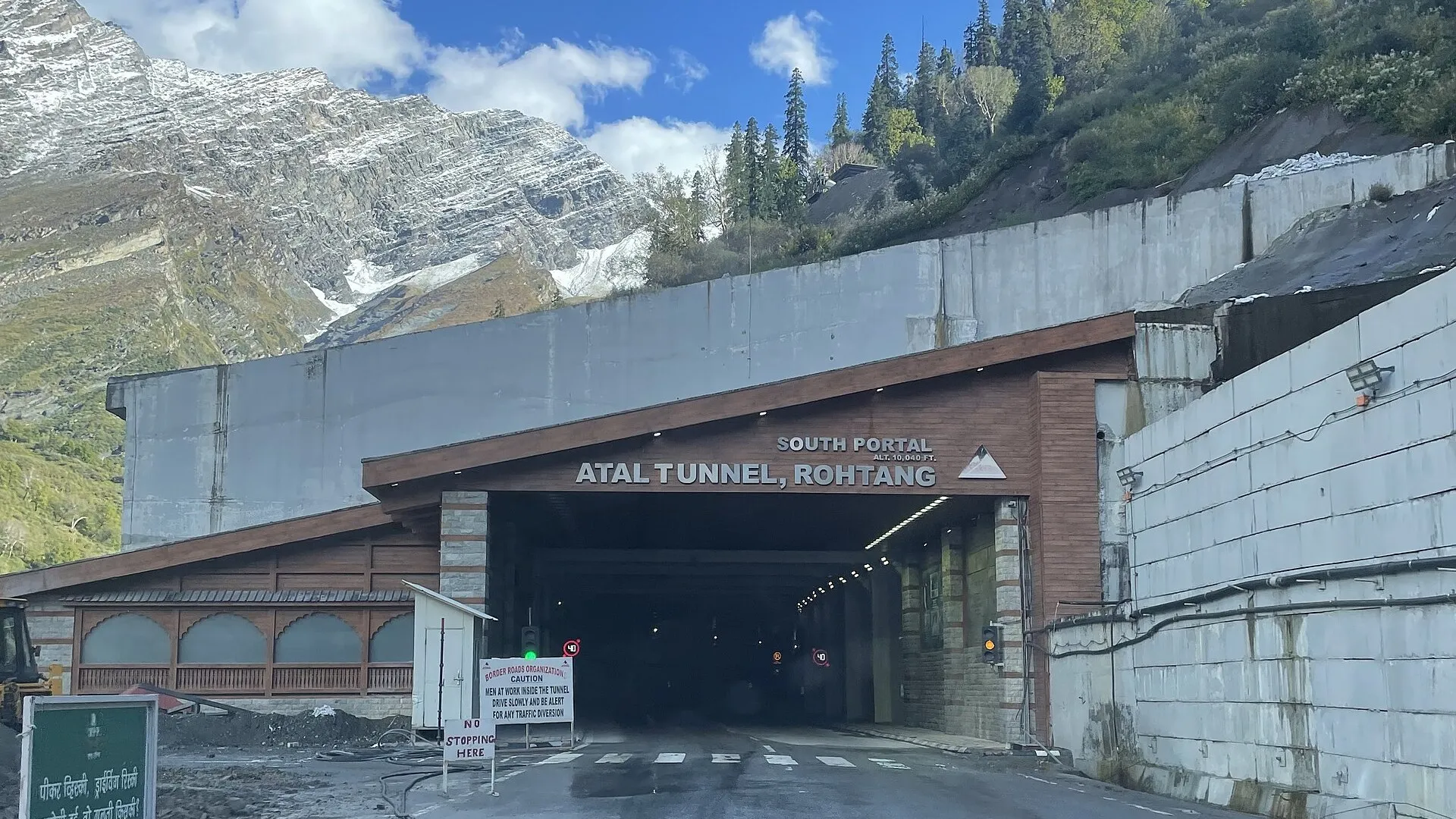 The south portal of the Atal Tunnel near Manali, with snow-streaked mountains behind