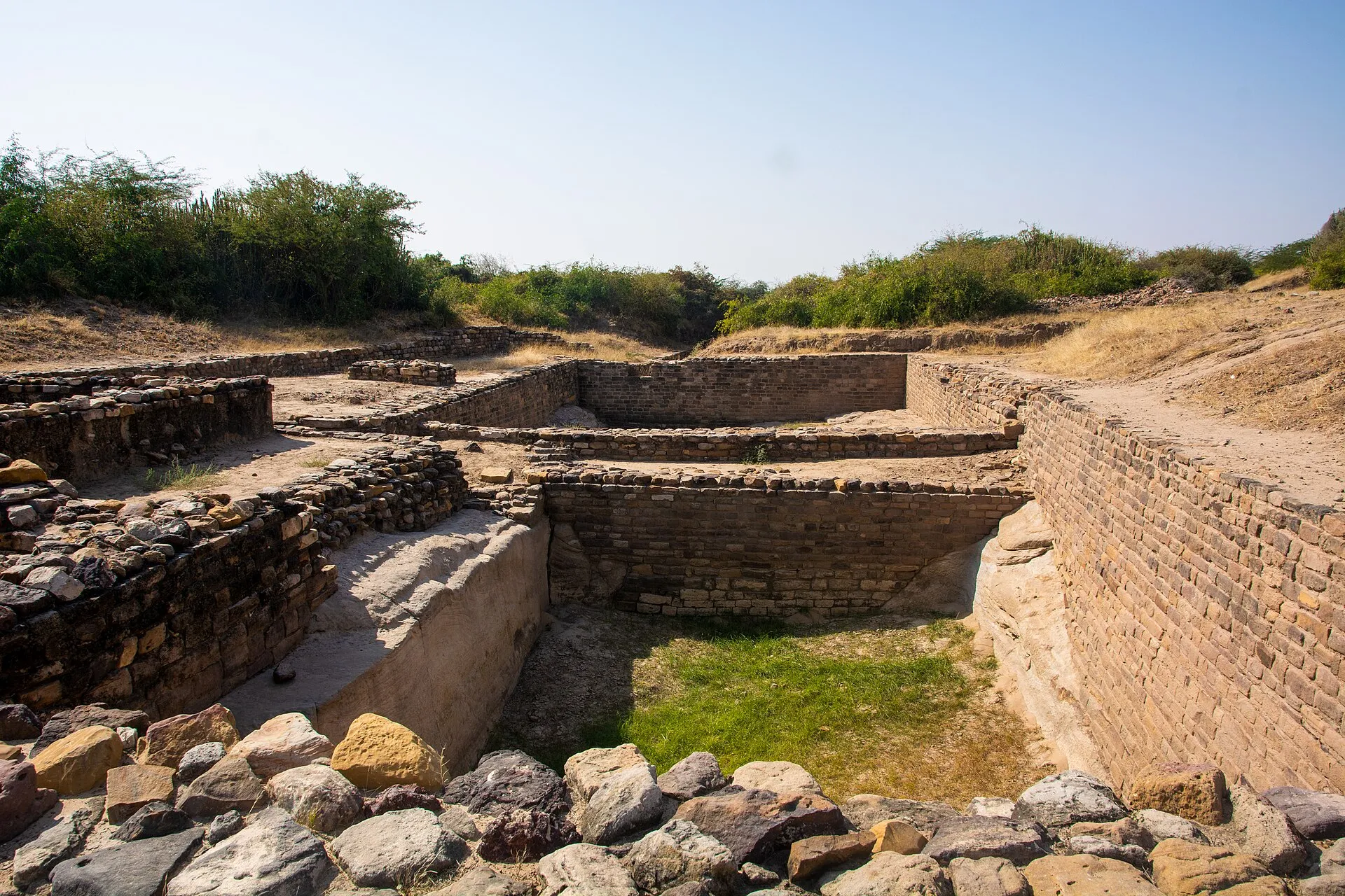 Excavated stone walls and a deep stone-lined reservoir at the Harappan site of Dholavira in Kutch