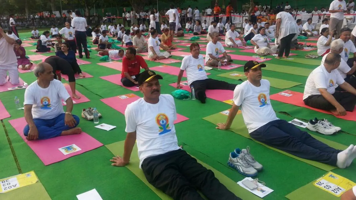 Rows of participants in white T-shirts practising yoga on mats at the first International Day of Yoga on Rajpath, New Delhi, 2015