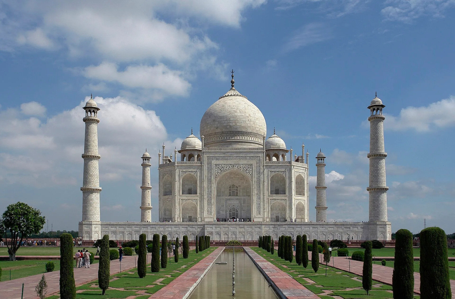 The white marble Taj Mahal with its four minarets, seen across the garden and long reflecting pool